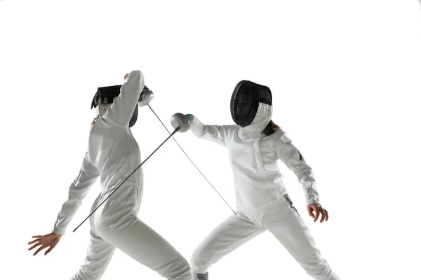 Chicas adolescentes en trajes de esgrima con espadas en las manos aisladas sobre fondo blanco — Foto de Stock