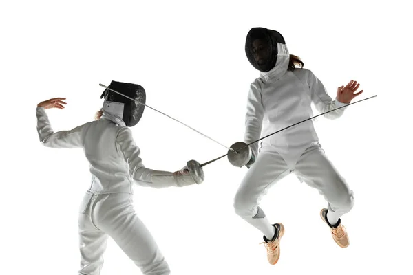 Девушки-фехтовальщики в костюмах с мечами в руках изолированы на белом фоне — стоковое фото