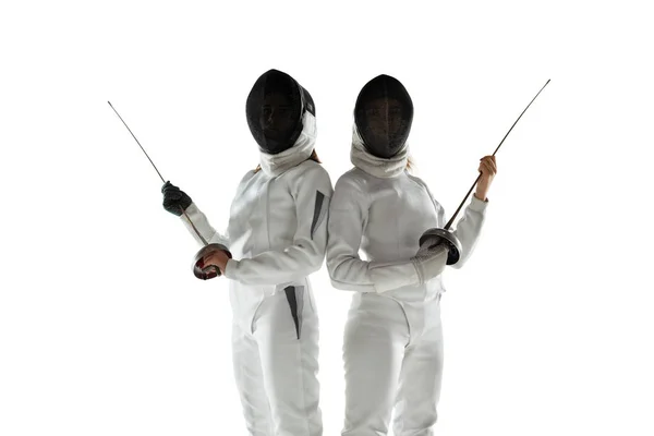 Tiener meisjes in schermen kostuums met zwaarden in handen geïsoleerd op witte achtergrond — Stockfoto
