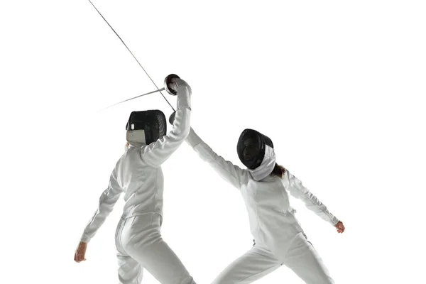 Teen girls in fencing costumes with swords in hands isolated on white background — Stock Photo, Image