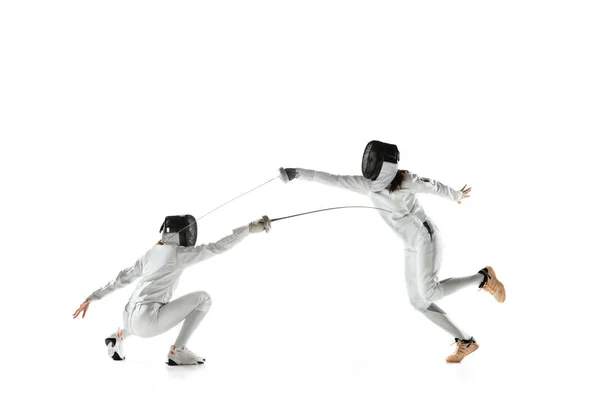 Teenager Mädchen in Fechtkostümen mit Schwertern in den Händen isoliert auf weißem Hintergrund — Stockfoto