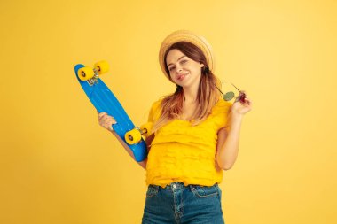 Sarı stüdyo arka planında izole edilmiş beyaz kadın portresi.