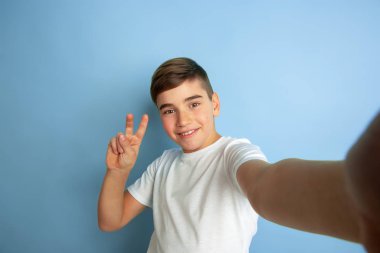 Mavi stüdyo arka planında izole edilmiş Kafkas gençlik portresi