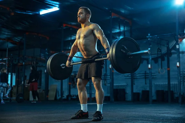 Hombre caucásico practicando levantamiento de pesas en gimnasio — Foto de Stock