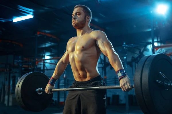 Hombre caucásico practicando levantamiento de pesas en gimnasio — Foto de Stock