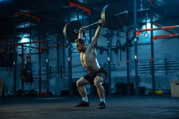 Hombre caucásico practicando levantamiento de pesas en gimnasio — Foto de Stock