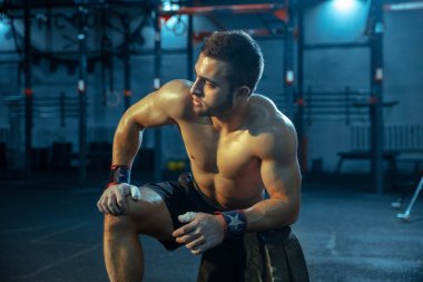 Spor salonunda ağırlık kaldırmada antrenman yapan beyaz bir adam.