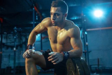 Spor salonunda ağırlık kaldırmada antrenman yapan beyaz bir adam.