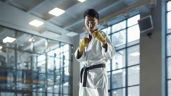 Уверенный корейский человек в кимоно, практикующий рукопашный бой, боевые искусства — стоковое фото