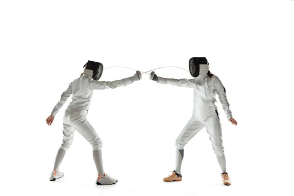 Adolescentes em trajes de esgrima com espadas em mãos isoladas no fundo branco — Fotografia de Stock