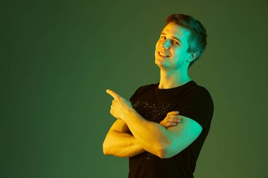 Beyaz adam portresi yeşil stüdyo arka planında neon ışıkta izole edilmiş.