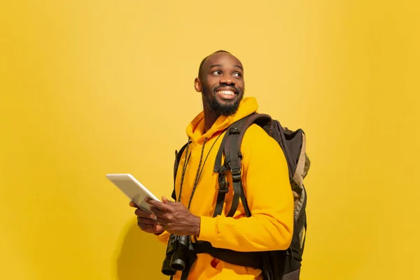 Retrato de comprimento total de um jovem turista africano alegre isolado no fundo amarelo — Fotografia de Stock