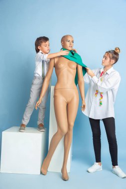 Küçük çocuk ve kız gelecekteki terzilik mesleğini hayal ediyorlar.