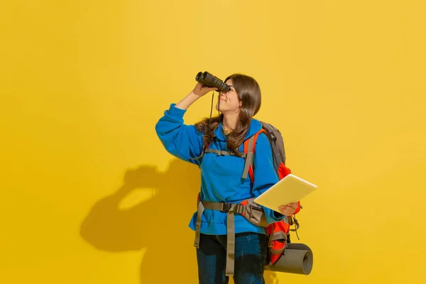 Plná délka portrét veselé mladé kavkazské turistické dívky izolované na žlutém pozadí — Stock fotografie