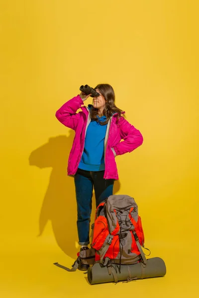Full length portret van een vrolijke jonge Kaukasische toeristische meisje geïsoleerd op gele achtergrond — Stockfoto
