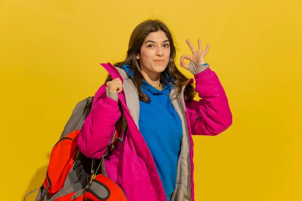 Porträtt av en glad ung kaukasiska turist flicka isolerad på gul bakgrund — Stockfoto