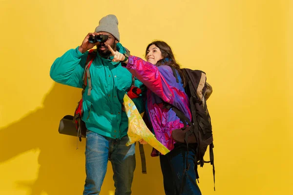 Portré egy vidám fiatal turista pár elszigetelt sárga háttér — Stock Fotó