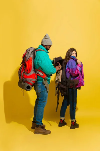 Portret wesołej młodej pary turystycznej odizolowanej na żółtym tle — Zdjęcie stockowe