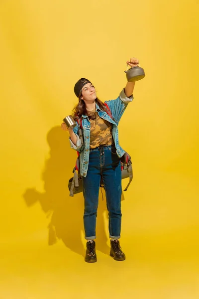 Porträt einer fröhlichen jungen kaukasischen Touristin isoliert auf gelbem Hintergrund — Stockfoto