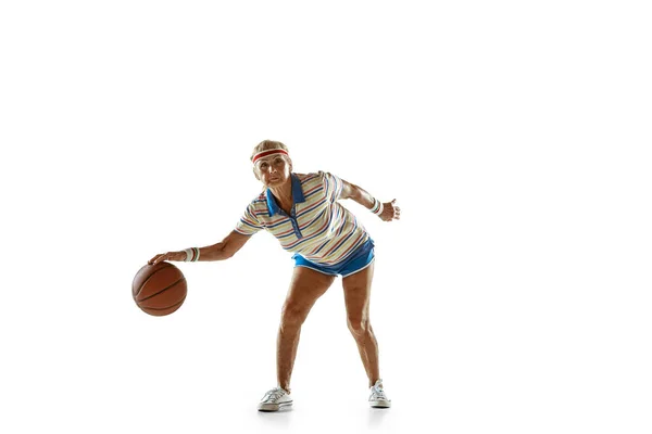 Seniorin spielt Basketball in Sportbekleidung auf weißem Hintergrund — Stockfoto