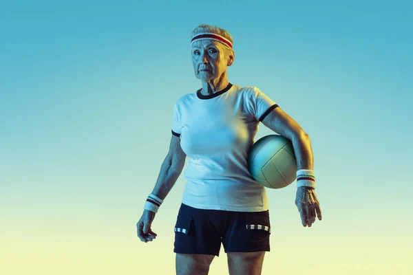 Idősebb női röplabda edzés sportruházat gradiens háttér neon fény — Stock Fotó