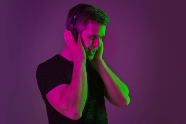 Beyaz adam portresi mor stüdyo arka planında neon ışıkta izole edilmiş.