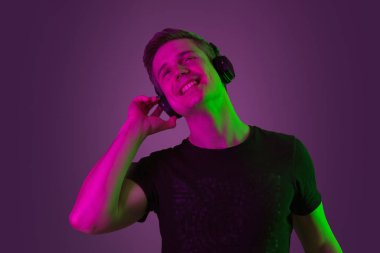 Beyaz adam portresi mor stüdyo arka planında neon ışıkta izole edilmiş.