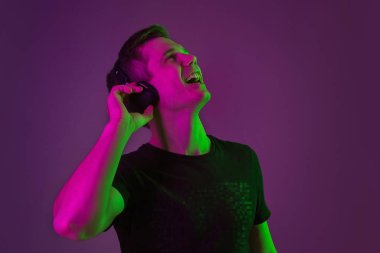 Beyaz adam portresi mor stüdyo arka planında neon ışıkta izole edilmiş.