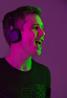 Beyaz adam portresi mor stüdyo arka planında neon ışıkta izole edilmiş.