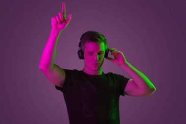 Beyaz adam portresi mor stüdyo arka planında neon ışıkta izole edilmiş.