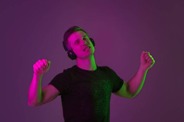 Beyaz adam portresi mor stüdyo arka planında neon ışıkta izole edilmiş.