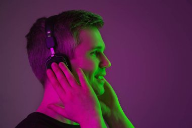 Beyaz adam portresi mor stüdyo arka planında neon ışıkta izole edilmiş.