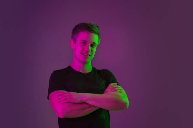 Beyaz adam portresi mor stüdyo arka planında neon ışıkta izole edilmiş.