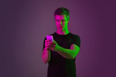 Beyaz adam portresi mor stüdyo arka planında neon ışıkta izole edilmiş.