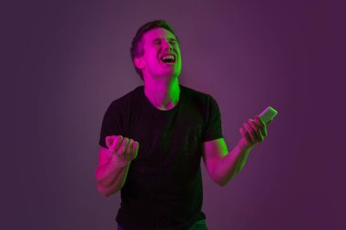 Beyaz adam portresi mor stüdyo arka planında neon ışıkta izole edilmiş.