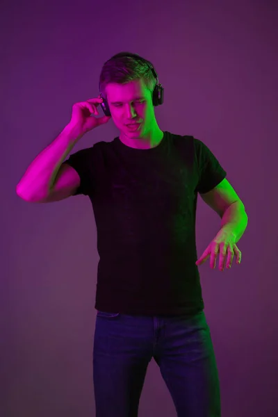 Caucasian mans portrait isolated on purple studio background in neon light — Stock Photo, Image