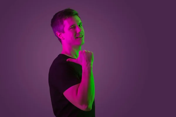 Caucasian mans portrait isolated on purple studio background in neon light — Stock Photo, Image