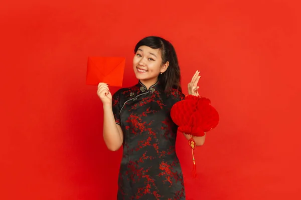Gott nytt kinesiskt år. Asiatiska unga flicka porträtt isolerad på röd bakgrund — Stockfoto