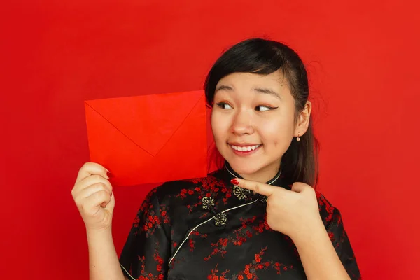 Gelukkig Chinees nieuwjaar. Aziatisch jong meisjesss portret geïsoleerd op rode achtergrond — Stockfoto