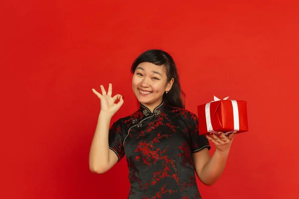 Yeni Çin yılın kutlu olsun. Asyalı genç kız portresi kırmızı arka planda izole edilmiş. — Stok fotoğraf