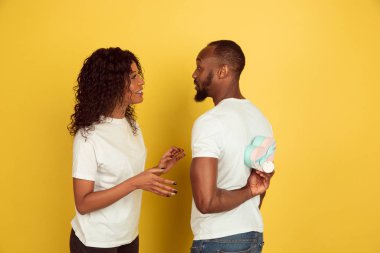 Sevgililer Günü kutlaması, mutlu Afro-Amerikan çifti sarı arka planda izole edilmiş.