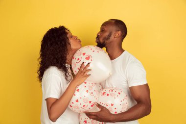 Sevgililer Günü kutlaması, mutlu Afro-Amerikan çifti sarı arka planda izole edilmiş.