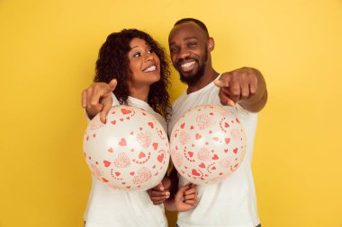 Sevgililer Günü kutlaması, mutlu Afro-Amerikan çifti sarı arka planda izole edilmiş.