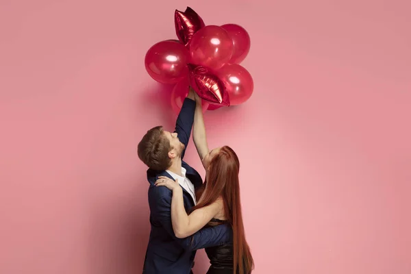 Valentines day celebration, happy caucasian couple isolated on coral background — 스톡 사진