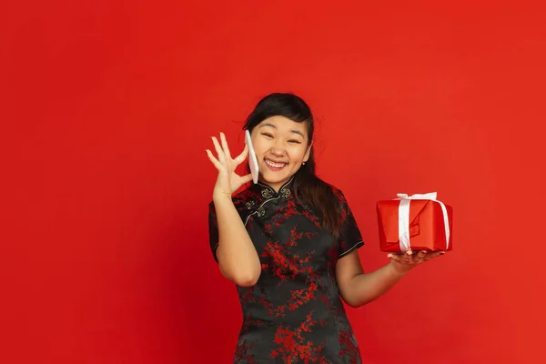 Yeni Çin yılın kutlu olsun. Asyalı genç kız portresi kırmızı arka planda izole edilmiş. — Stok fotoğraf