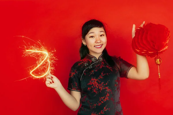 Gott nytt kinesiskt år. Asiatiska unga flicka porträtt isolerad på röd bakgrund — Stockfoto