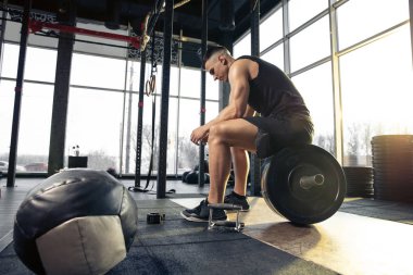 Erkek sporcu spor salonunda sıkı antrenman yapıyor. Fitness ve sağlıklı yaşam konsepti.