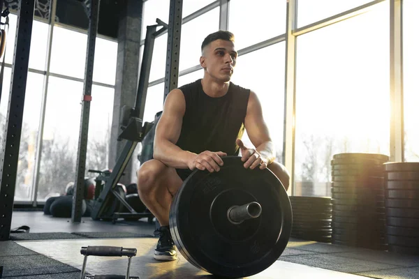 El atleta masculino entrena duro en el gimnasio. Fitness y concepto de vida saludable . — Foto de Stock