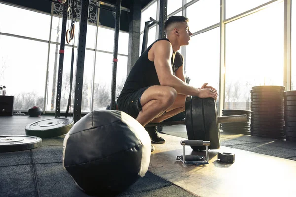 Erkek sporcu spor salonunda sıkı antrenman yapıyor. Fitness ve sağlıklı yaşam konsepti.