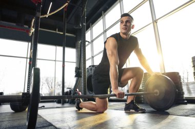 Erkek sporcu spor salonunda sıkı antrenman yapıyor. Fitness ve sağlıklı yaşam konsepti.